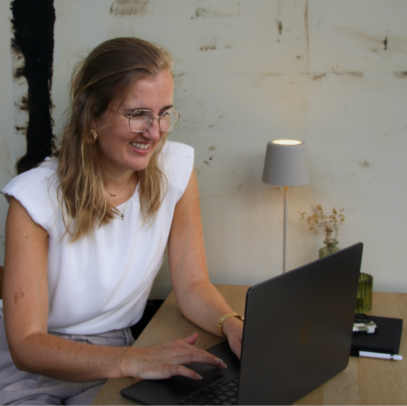 Tirza van Tirs Content & Creatie werkt lachend achter haar laptop